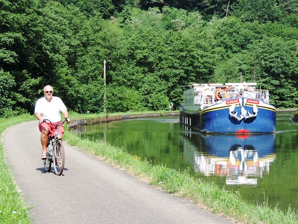 Disfrute de un encantador paseo en bicicleta por el canal que acompaña al canal CRUCEROS FLUVIALES CANALES DE FRANCIA LA PANACHE CRUCEROS FLUVIALES DE LUJO CANAL DE LA MARNE AU RHIN LE PANACHE BICICLETA VACACIONES EN BICI